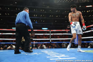 A Boxer Is Standing On The Ring With A Referee Wallpaper
