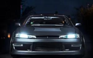 A Car With Lights On In The Dark Wallpaper