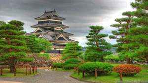A Castle With Trees And Bushes Wallpaper