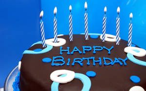 A Chocolate Birthday Cake With Sky-blue Candles Wallpaper