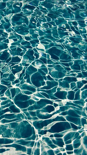 A Close Up Of A Blue Pool With Ripples Wallpaper