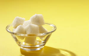 A Crystal Clear Bowl Filled With Sugar Cubes Wallpaper