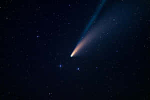 A Dazzling Comet Streaks Across The Night Sky Wallpaper