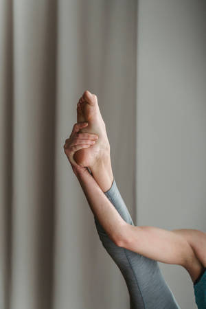 A Fitness Enthusiast Stretching Her Lower Body Wallpaper