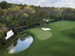 A Golf Course With A Pond And Trees Wallpaper