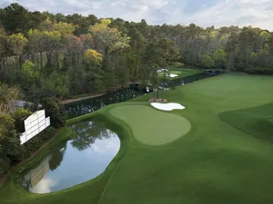 A Golf Course With A Pond And Trees Wallpaper