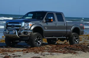 A Gray Truck Is Parked On The Beach Wallpaper