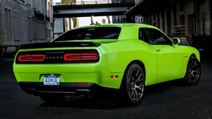 A Green Dodge Challenger Parked On A Street Wallpaper
