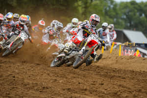 A Group Of Dirt Bikers Racing On A Dirt Track Wallpaper