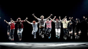 A Group Of People Jumping In The Air Wallpaper