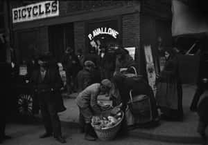 A Group Of People Standing Outside Of A Bicycle Shop Wallpaper