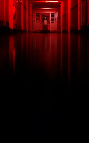 A Hallway With Red Lights And A Person In The Middle Wallpaper