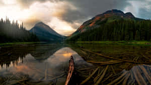 A Lake With Trees And Mountains Wallpaper