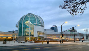 A Large Building With A Glass Roof And A Street Wallpaper