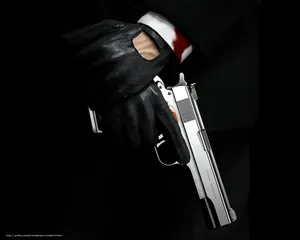 A Man In A Suit Holding A Gun Wallpaper