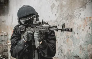 A Man In Black Is Holding An Ak-47 Rifle Wallpaper