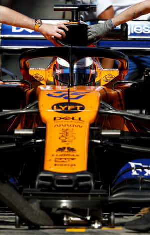 A Man Is Working On The Front Of A Racing Car Wallpaper