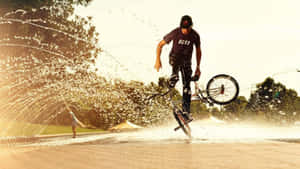 A Man Riding A Bike In The Water Wallpaper