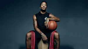 A Man Sitting On A Box Holding A Basketball Wallpaper