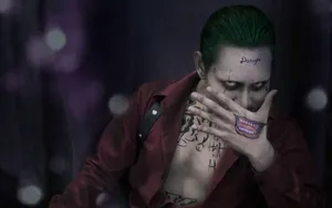 A Man With Green Hair And Tattoos Is Sitting On A Chair Wallpaper