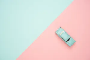 A Mini Toy Car In Pastel Green Wallpaper