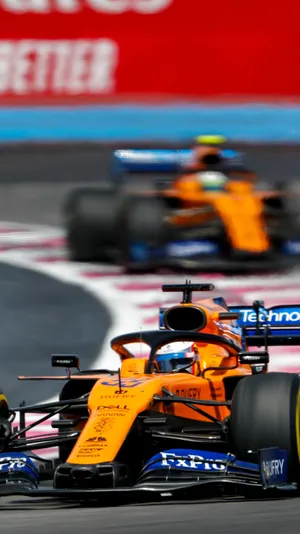 A Orange And Blue Racing Car On A Track Wallpaper