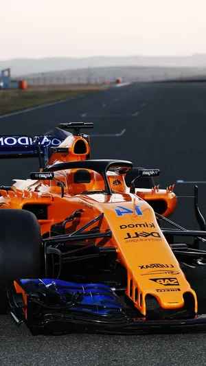 A Orange And Blue Racing Car On A Track Wallpaper
