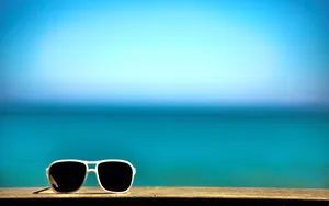 A Pair Of Sunglasses On A Wooden Bench Wallpaper
