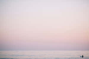 A Person Is Standing On The Beach At Sunset Wallpaper