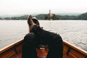 A Person's Feet Are Resting On The Back Of A Boat Wallpaper