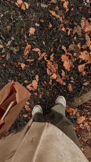 A Person Standing On A Grassy Area With A Bag Wallpaper