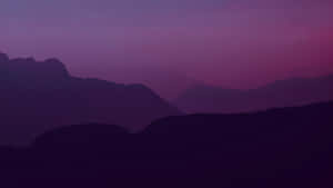 A Purple Sky With Mountains Wallpaper