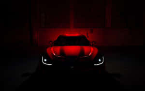 A Red Sports Car Is Lit Up In The Dark Wallpaper