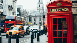 A Red Telephone Booth On A Street Wallpaper