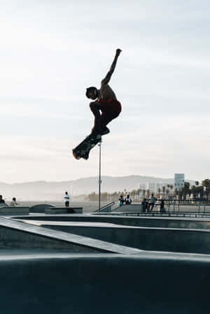 A Skateboarder Performing A Grind On A Rail Wallpaper