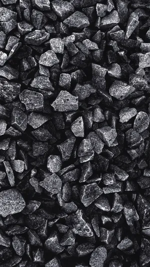 A Sleek Grey Iphone Resting On A Pile Of Rocks Wallpaper