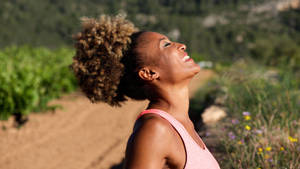 A Smiling African Woman Enjoying A Healthy Workout Wallpaper