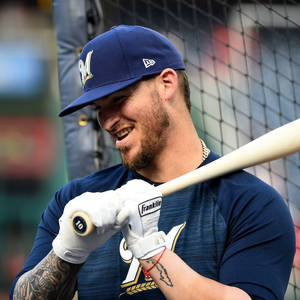 A Smiling Yasmani Grandal Holding A Baseball Bat Wallpaper