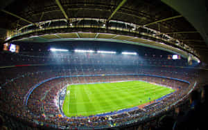 A Soccer Stadium With Many People Watching The Game Wallpaper