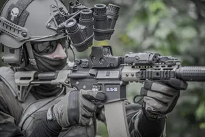 A Soldier Is Holding A Rifle And Looking At The Camera Wallpaper