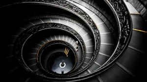 A Spiral Staircase With A Person On It Wallpaper