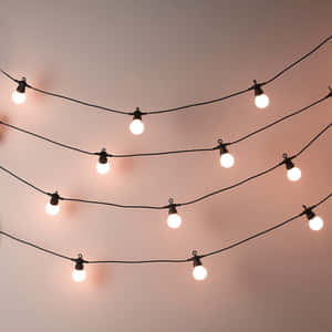 A String Of Lights With A Pink Bulb Wallpaper