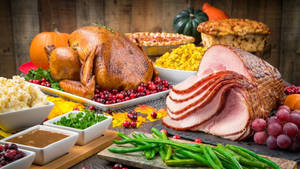 A Sumptuous Feast Of Ham And Roasted Turkey For Dinner Wallpaper