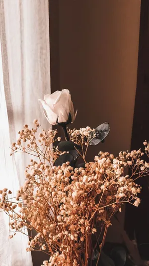 A Vase Of Dried Flowers On A Table Wallpaper