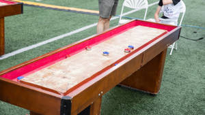 A Vibrant Indoor Shuffleboard Game In Action Wallpaper