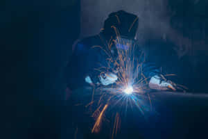 A Welder Is Working On A Metal Piece Wallpaper