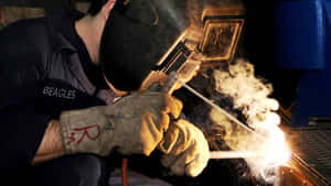 A Welder Perfectly Joining Two Pieces Of Stainless Steel Wallpaper