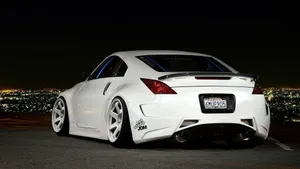 A White Sports Car Parked In Front Of A City Wallpaper