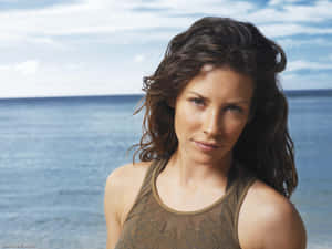 A Woman With Long Hair Standing On The Beach Wallpaper