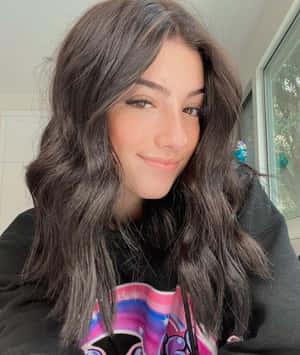 A Young Woman With Long Hair And A Black Sweatshirt Wallpaper